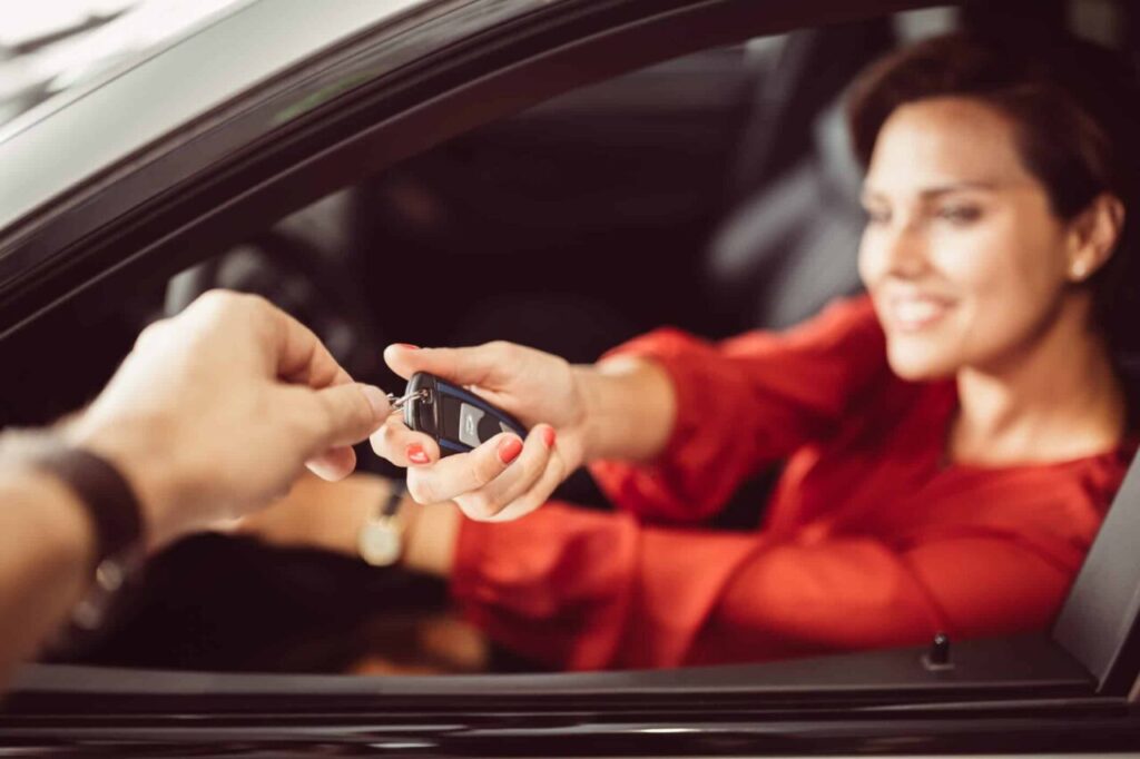 Como calcular o preço de um carro usado: guia prático 3 Imagem de mulher pegando a chave do carro