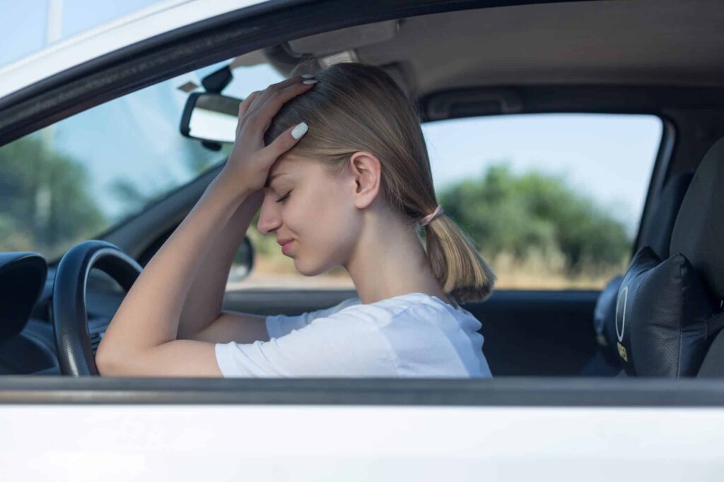 Mulher dentro do carro com as duas mãos na cabeça - Vender carros com mais de 5 anos de uso