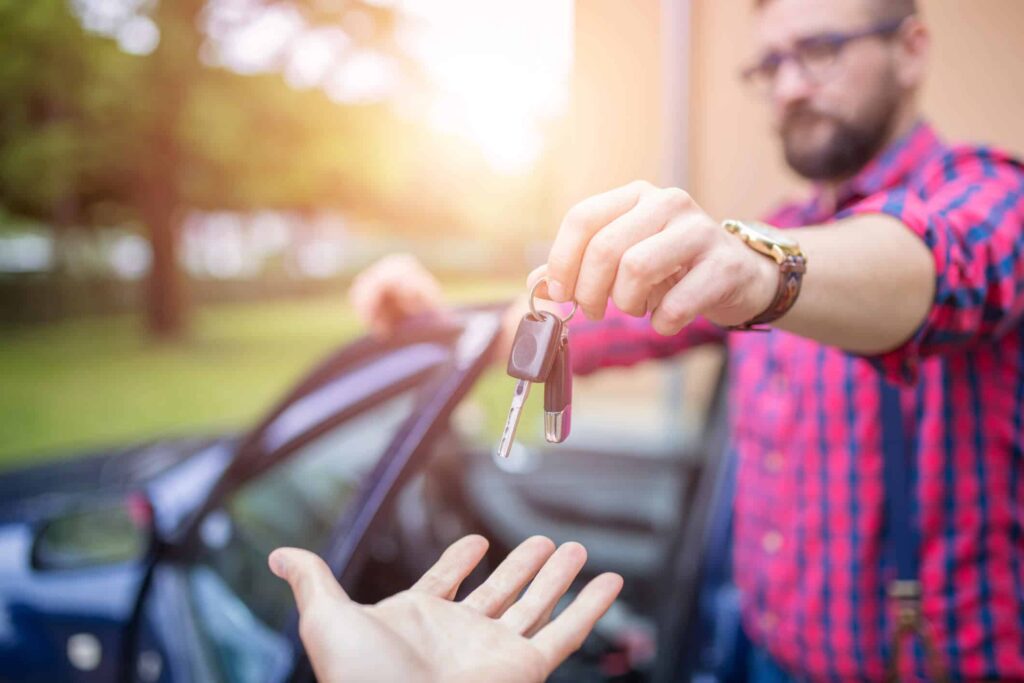homem entregando chave do carro para outra pessoa