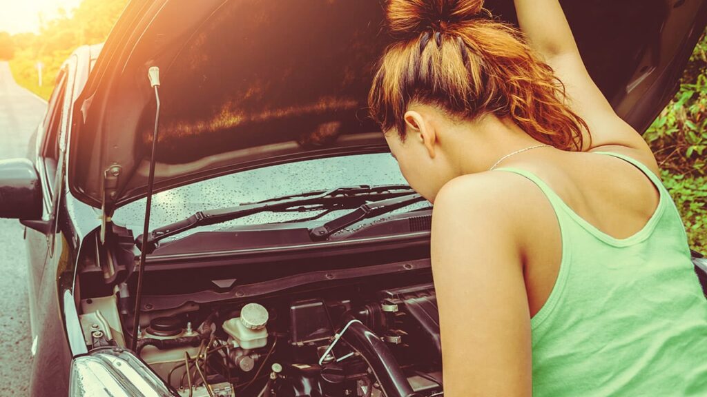 O motor de arranque parou? Como evitar que isso se repita 8 Mulher olhando para o motor de um carro com defeito - motor de arranque