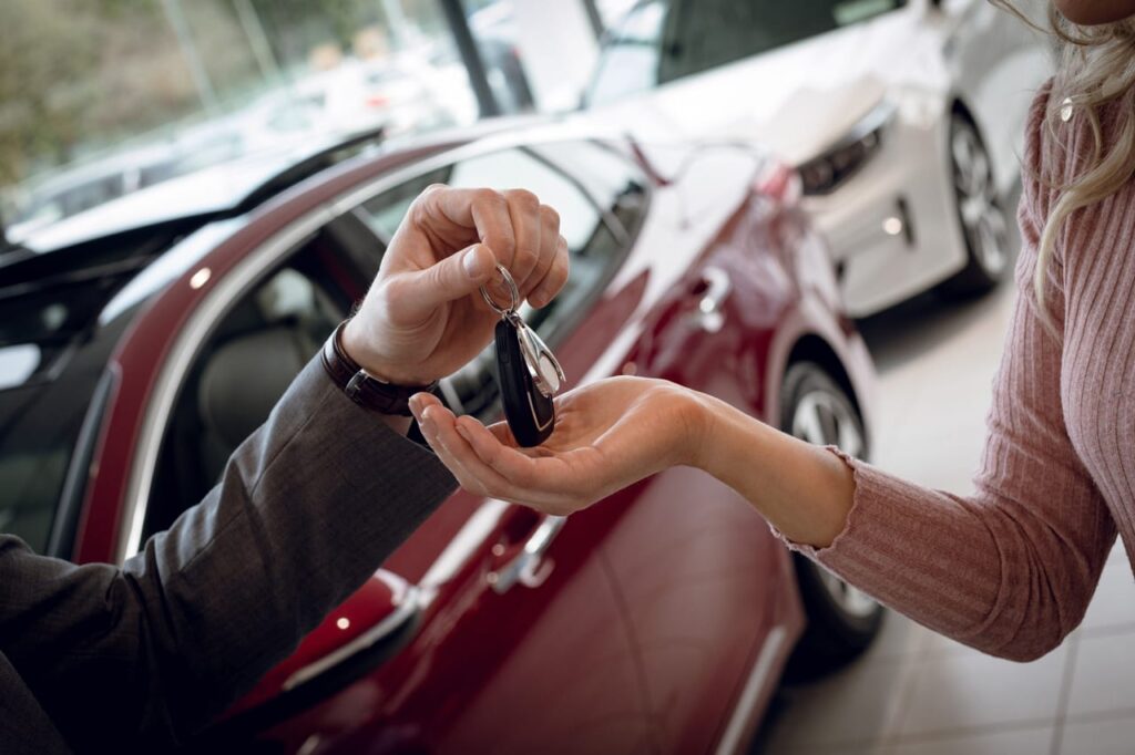 aluguel de carro - mão masculina entregando uma chave de carro para outra mão feminina