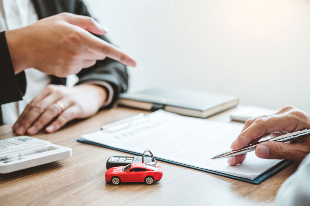 Os carros mais baratos do Brasil de cada segmento 4 carros mais baratos do Brasil - pessoa comprando carro fazendo contas