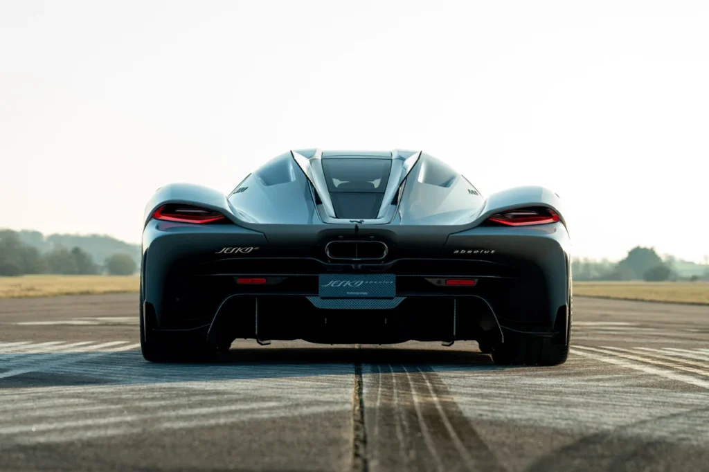 carro mais rápido do mundo - Vista traseira do Koenigsegg Jesko Absolut em uma pista, destacando o design aerodinâmico e as lanternas afiladas do hipercarro.