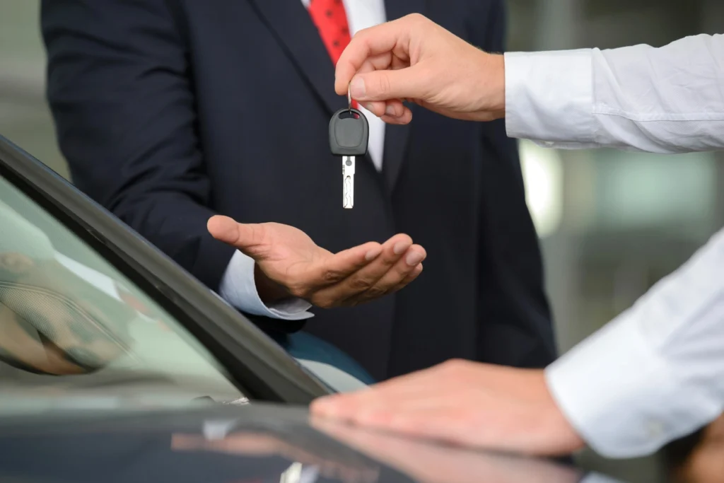 homem passando a chave do carro para outro