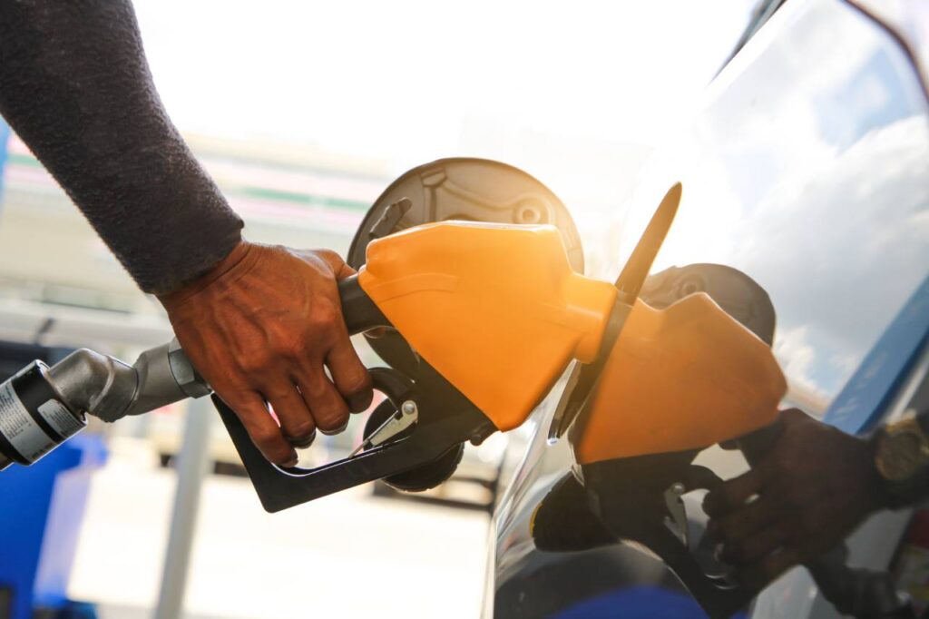 mão masculina abastecendo veiculo delivery de gasolina