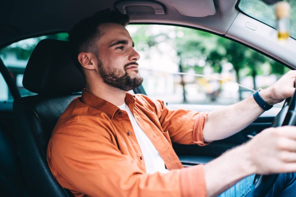 Seguro do carro por quilômetro rodado - homem feliz dirigindo um carro
