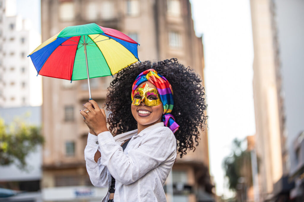 Viagem de Carnaval: o guia Completo para revisar seu carro antes de pegar a estrada 3 viagem de carnaval - viajar de carro no carnaval - mulher de máscara e guarda-chuva de frevo no carnaval