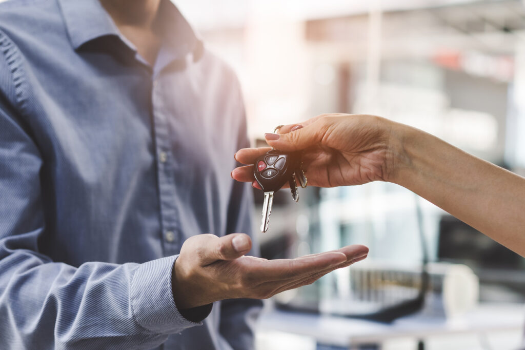 vender carro em Duque de Caxias - mão de mulher entregando uma chave de carro na mão de um homem