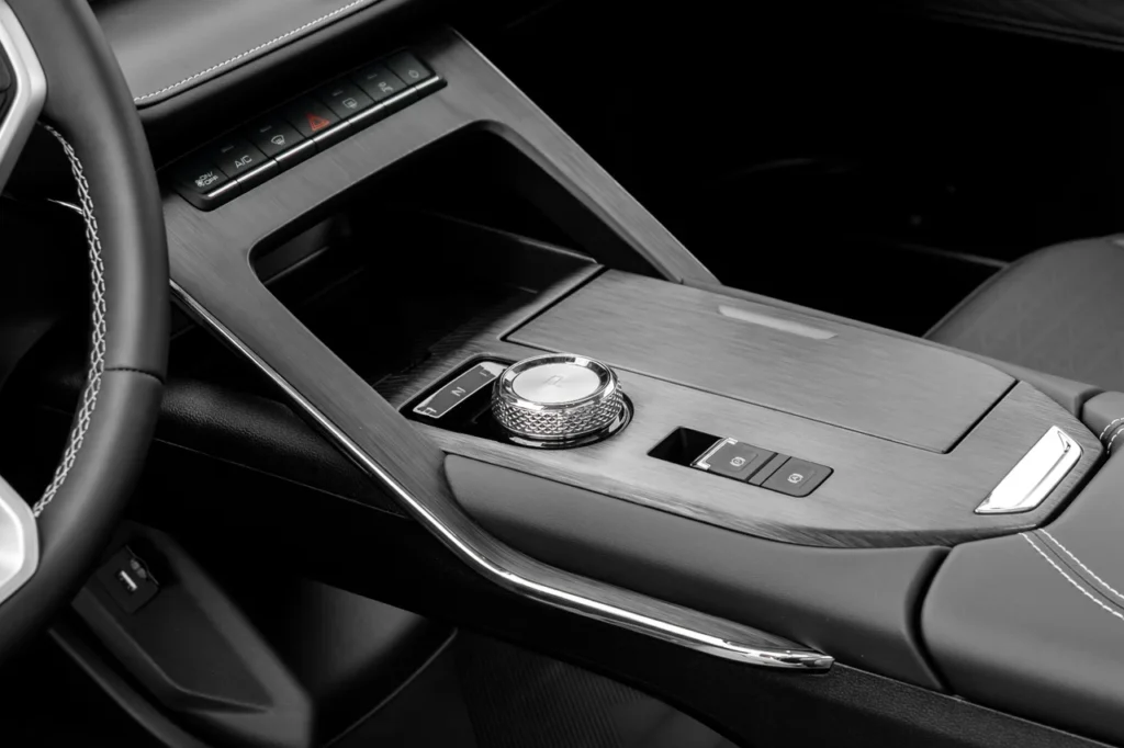 Detalhe da alavanca de câmbio rotativa e botões centrais do console do GWM Haval H6.
