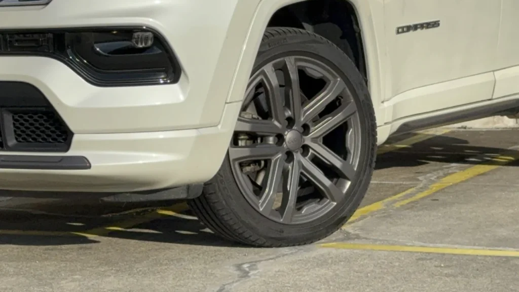 Jeep Compass Overland: SUV de R$ 285 mil que anda como um Premium 8 Detalhe da roda dianteira do Jeep Compass Overland 2025 branco pérola com acabamento esportivo