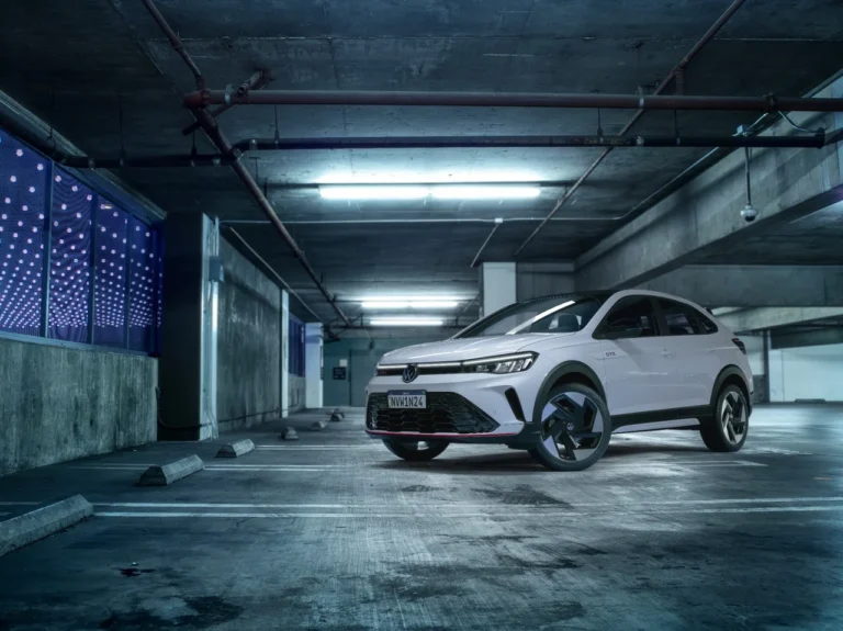 Lançamentos 5 Traseira do Nivus GTS 2026 iluminada por luzes urbanas, realçando o logo e detalhes esportivos.