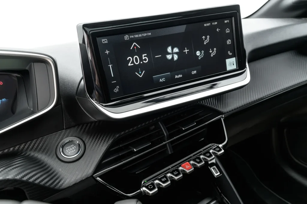 Ar-condicionado aumenta o consumo? Saiba o impacto real 1 Painel digital de um Peugeot 208 Turbo Style exibindo os controles do sistema de climatização, ilustrando como o uso do ar-condicionado aumenta o consumo de combustível