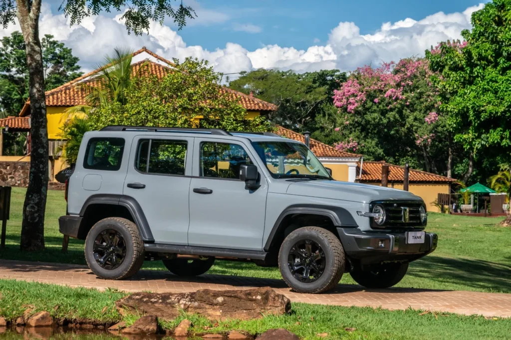 GWM Tank 300 chega por R$ 333 mil para bater de frente com Toyota SW4 27 Lateral do GWM Tank 300 em uma entrada de sítio arborizado e florido