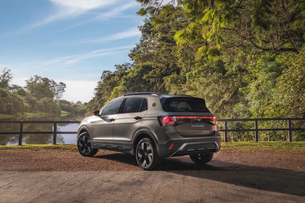 Volkswagen T-Cross Extreme: Novo SUV com pintura fosca beira os R$ 200 mil 1 Volkswagen T-Cross Extreme visto de traseira e lateral em um cenário arborizado com lago ao fundo, evidenciando o design das lanternas e o logotipo da Volkswagen