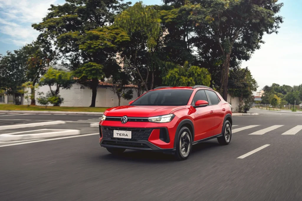 Os 5 SUVs mais baratos do Brasil de 2025 3 VW Tera vermelho em movimento em uma avenida arborizada, destacando seu design esportivo e robusto.