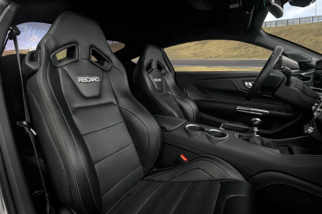 Mustang GT Manual 2025: edição limitada com 492 cv e câmbio manual 8 Interior do Ford Mustang GT Manual Performance com bancos esportivos Recaro em couro preto, costura branca e acabamento sofisticado.