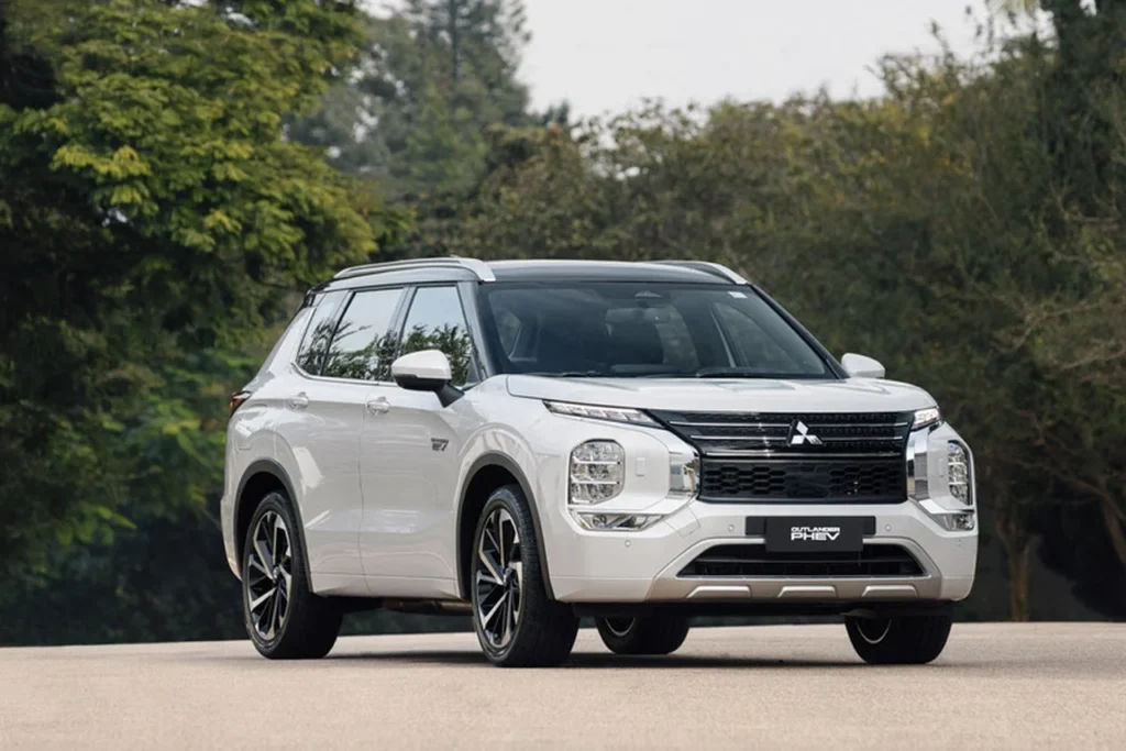 Novo Mitsubishi Outlander 2025 chega ao Brasil com motor híbrido plug-in e até 844 km de autonomia 1 Vista frontal do Mitsubishi Outlander PHEV 2025 em um ambiente externo, destacando o design moderno, faróis em LED e grade imponente.