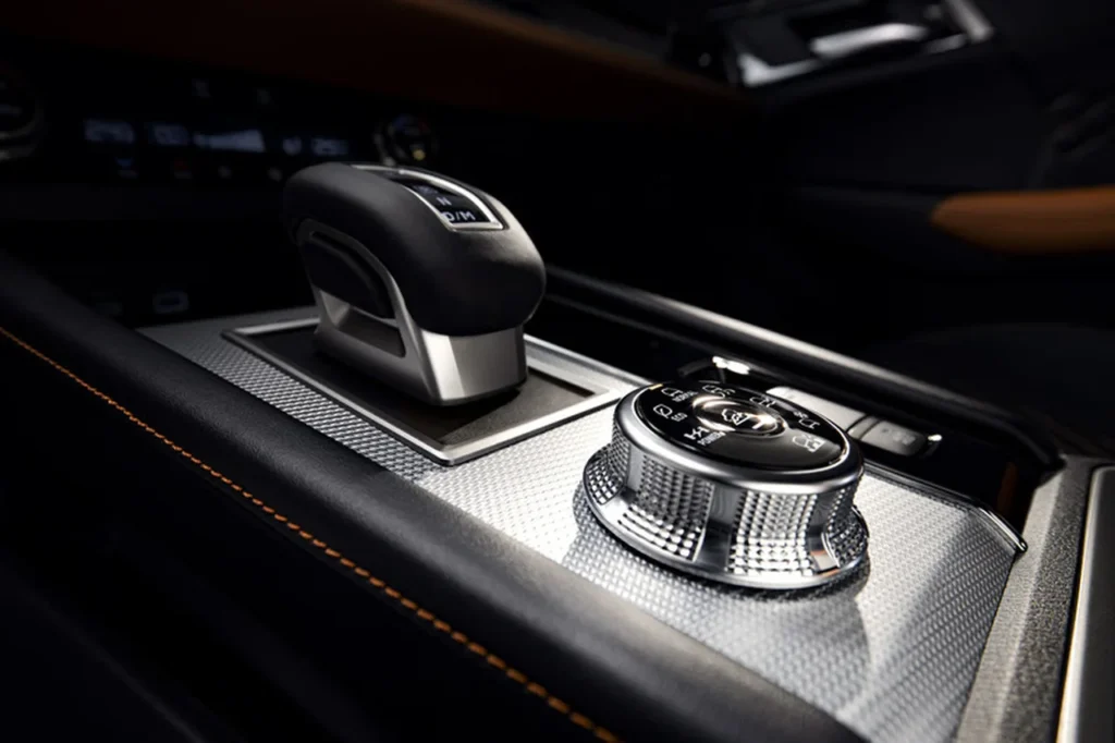 Novo Mitsubishi Outlander 2025 chega ao Brasil com motor híbrido plug-in e até 844 km de autonomia 1 Detalhe do console central do Mitsubishi Outlander PHEV 2025 com seletor de modos de condução e alavanca de câmbio futurista.
