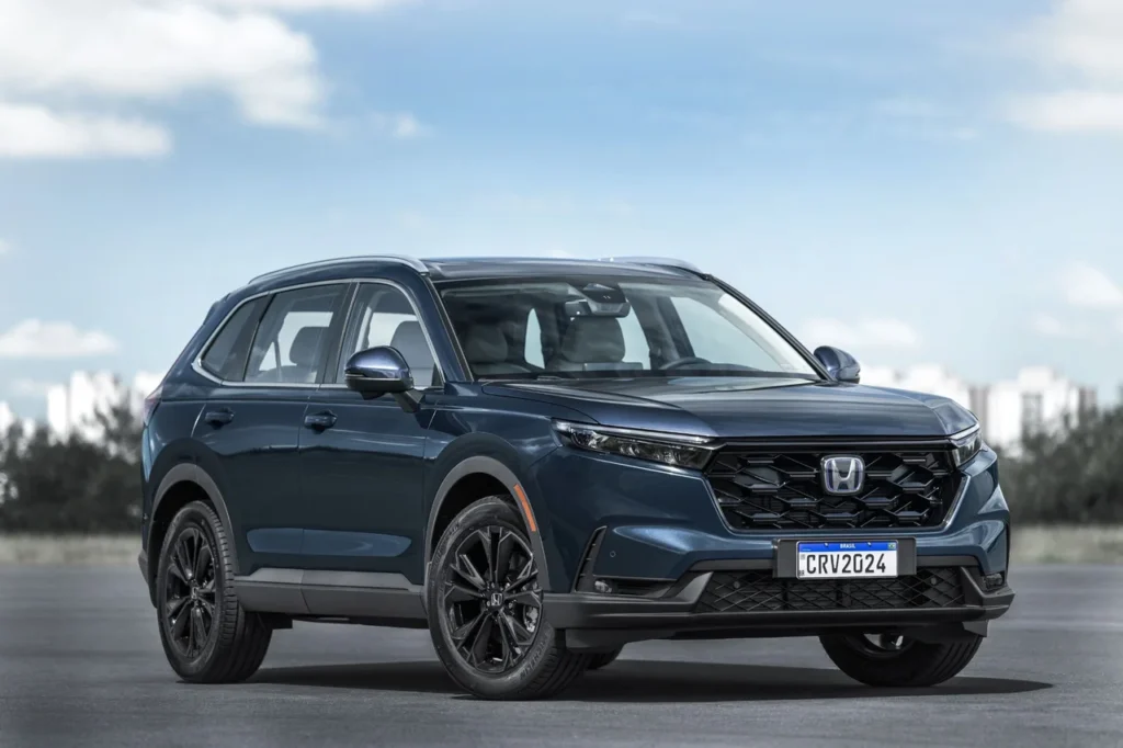 Honda CR-V híbrido 2025: SUV caro, mas com tração integral e alto nível de eficiência 5 Vista frontal em ângulo do Honda CR-V híbrido 2025 em um ambiente externo, destacando os faróis afilados e grade frontal.