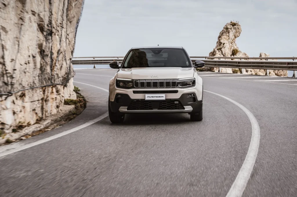Jeep Avenger será produzido no Brasil a partir de 2026 8 Jeep Avenger visto de frente enquanto percorre uma estrada sinuosa entre rochas.