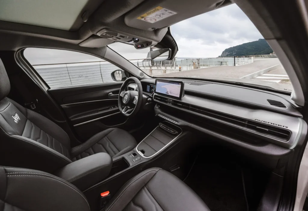 Jeep Avenger será produzido no Brasil a partir de 2026 6 Painel e volante do Jeep Avenger vistos do banco do passageiro, com destaque para a central multimídia e acabamento moderno.