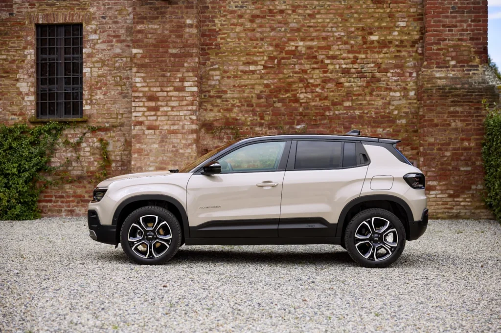 Jeep Avenger será produzido no Brasil a partir de 2026 4 Vista lateral do Jeep Avenger em um terreno com pedras e uma parede de tijolos ao fundo.