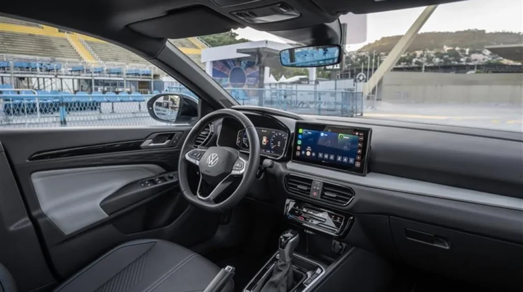Volkswagen Tera estreia com preços a partir de R$ 99.990 5 Vista lateral interna do VW Tera, com destaque para o painel digital, alavanca de câmbio automática e detalhes em preto fosco.