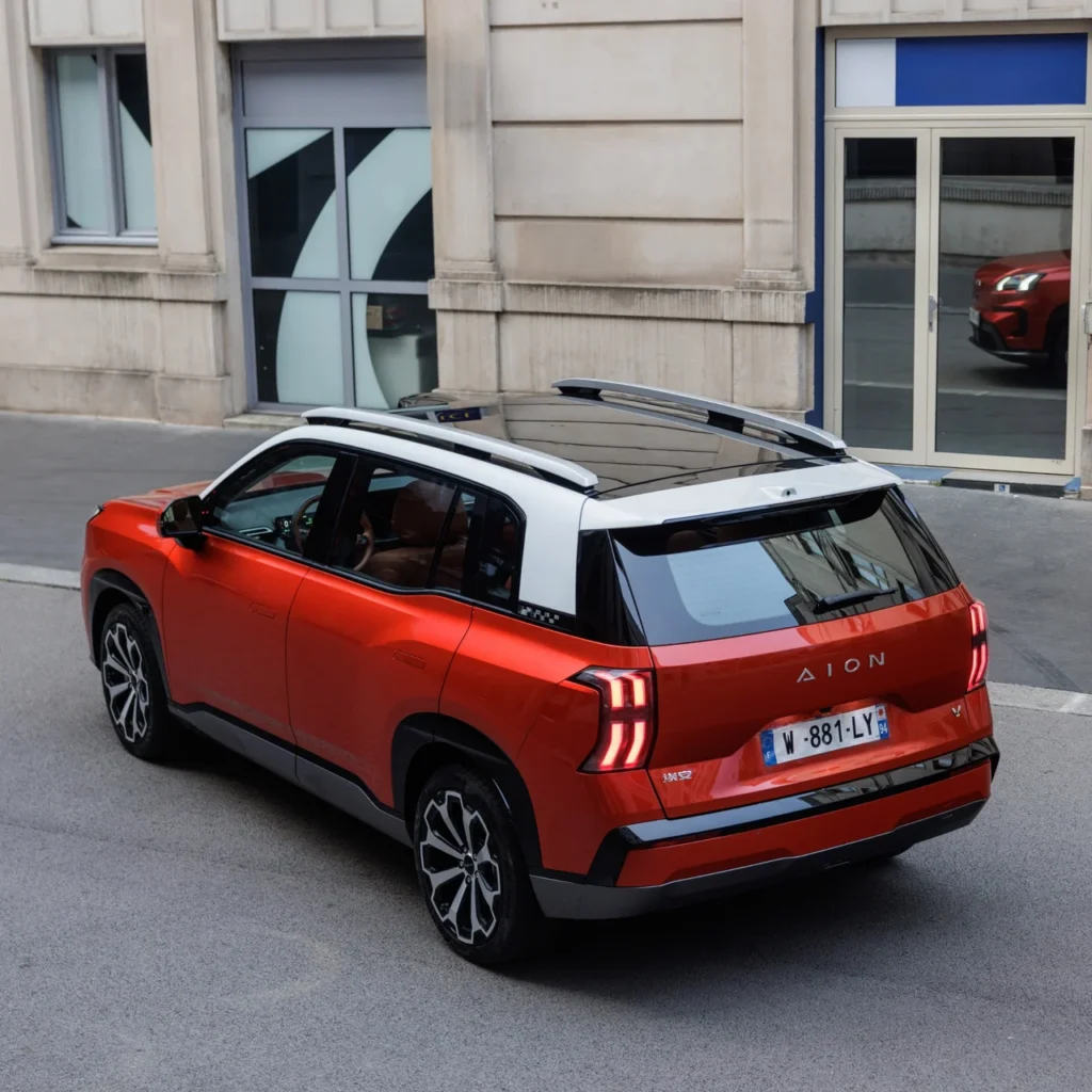 GAC estreia no Festival de Interlagos com linha elétrica completa e preços a partir de R$ 169.990 6 GAC AION V vermelho em rua urbana com arquitetura clássica ao fundo