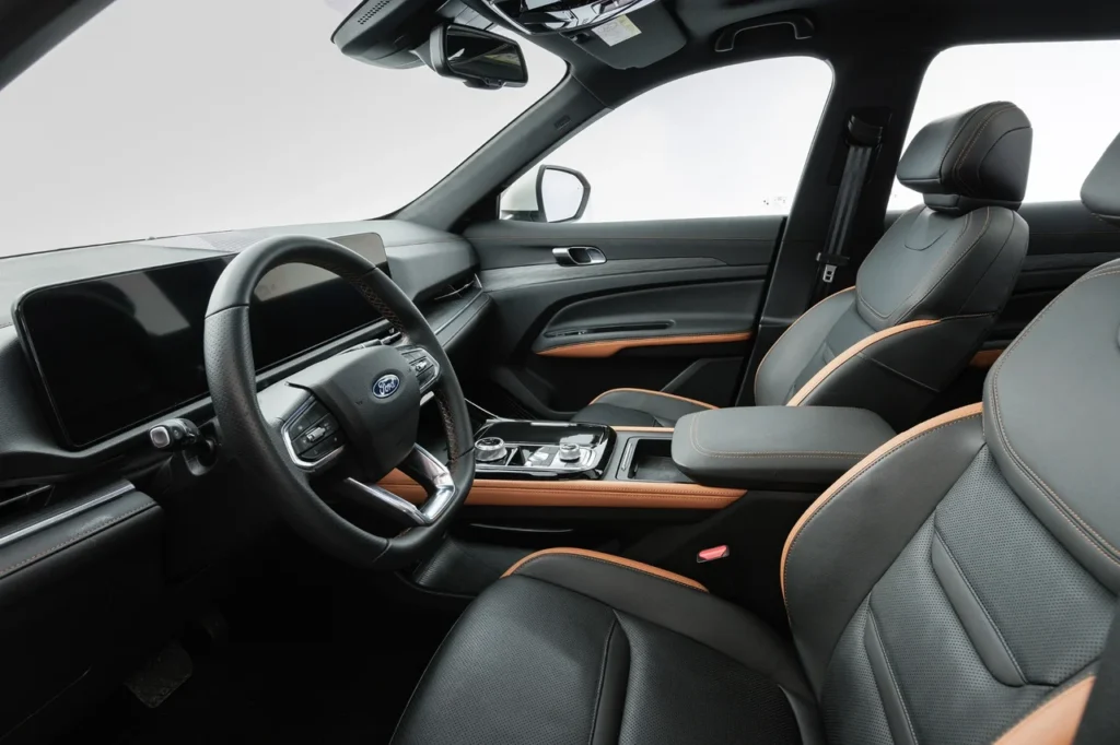 Novo Ford Territory 2026 tem novo visual revelado e estreia confirmada no Brasil 4 Interior moderno do Ford Territory, destacando painel digital, volante multifuncional e acabamento com detalhes em couro