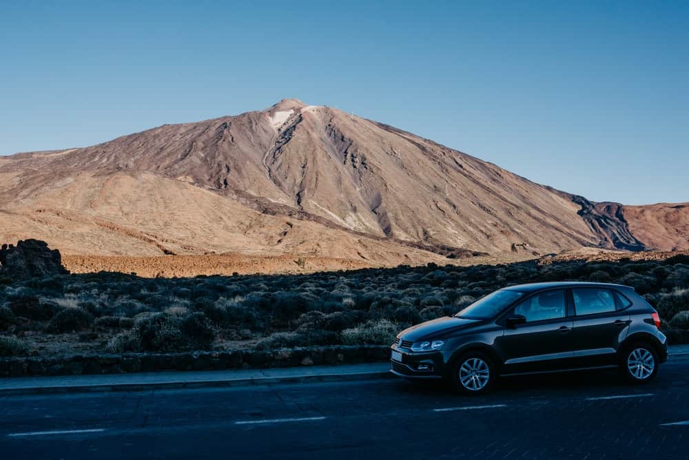 Imagem de veículo trafegando por paisagem com montanha