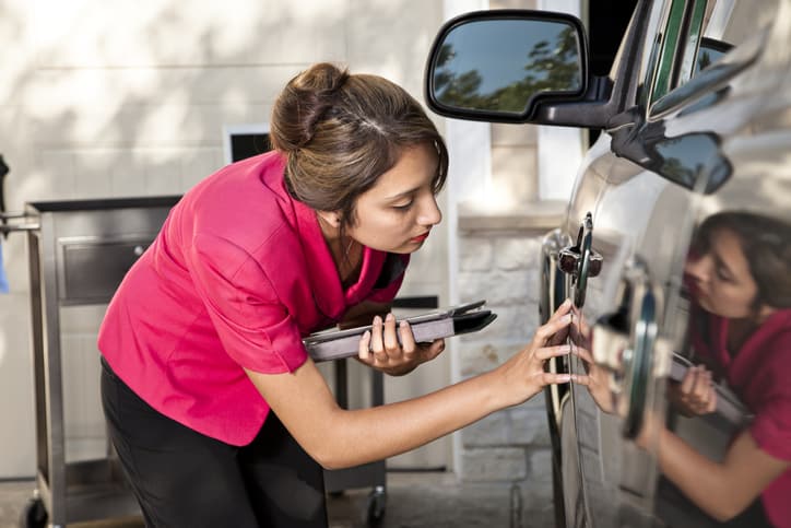 Imagem de mulher analisando para ver se há defeito na porta do carro
