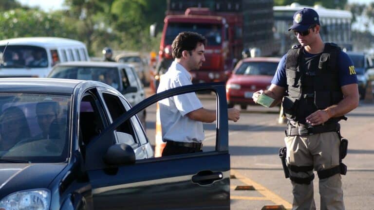 Homem levando multa de guarda de trânsito