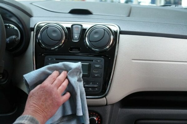mão limpando painel do carro