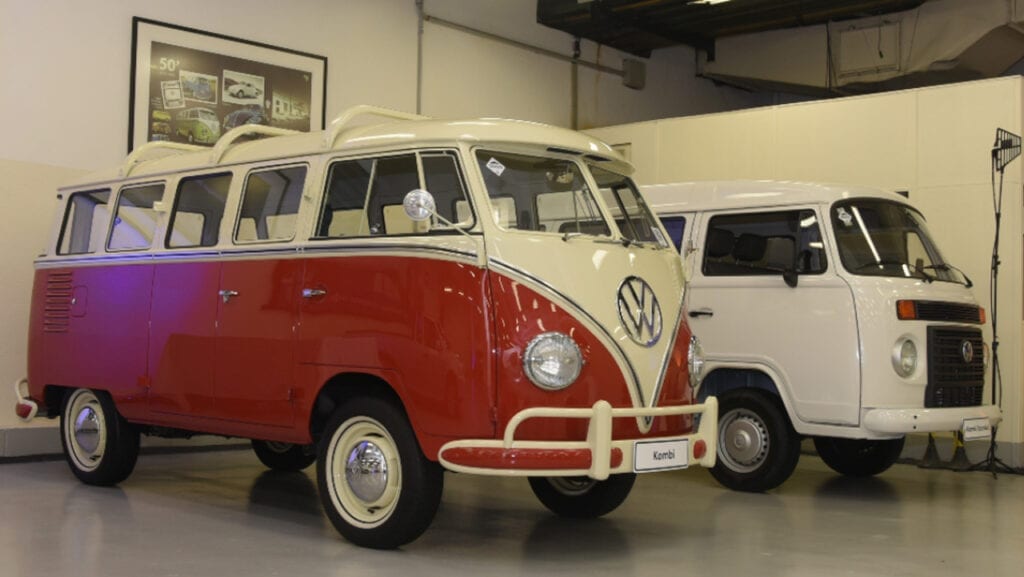 Volkswagen Kombi branca e vermelha dos anos 60 e uma branca dos anos 2000