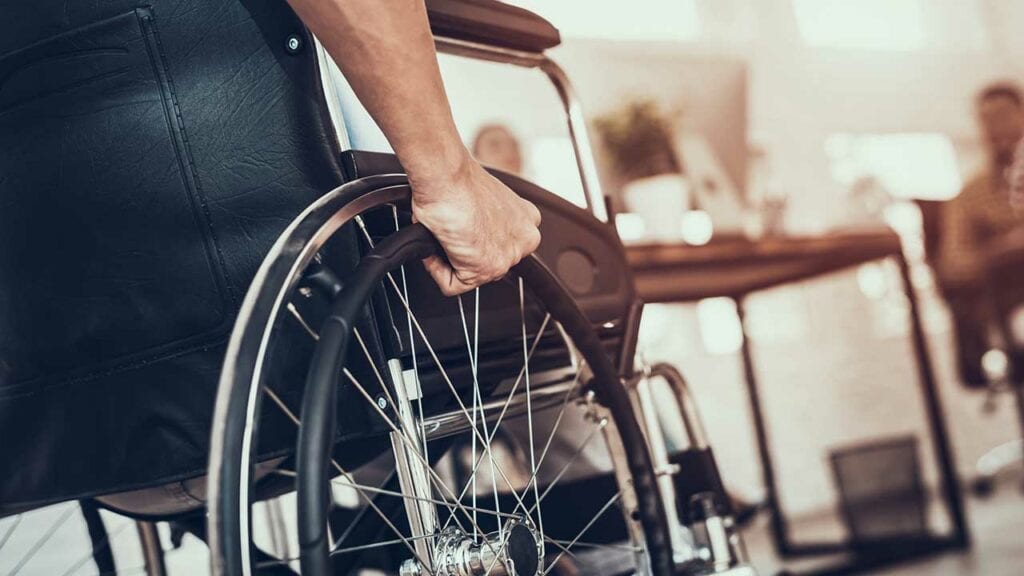 Pessoa andando com cadeira de rodas - Carro PCD