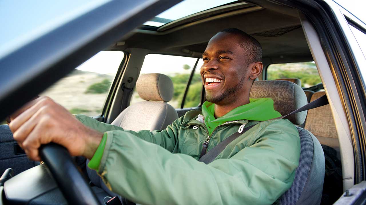 Homem sorridente pilotando um automóvel - O que é potência