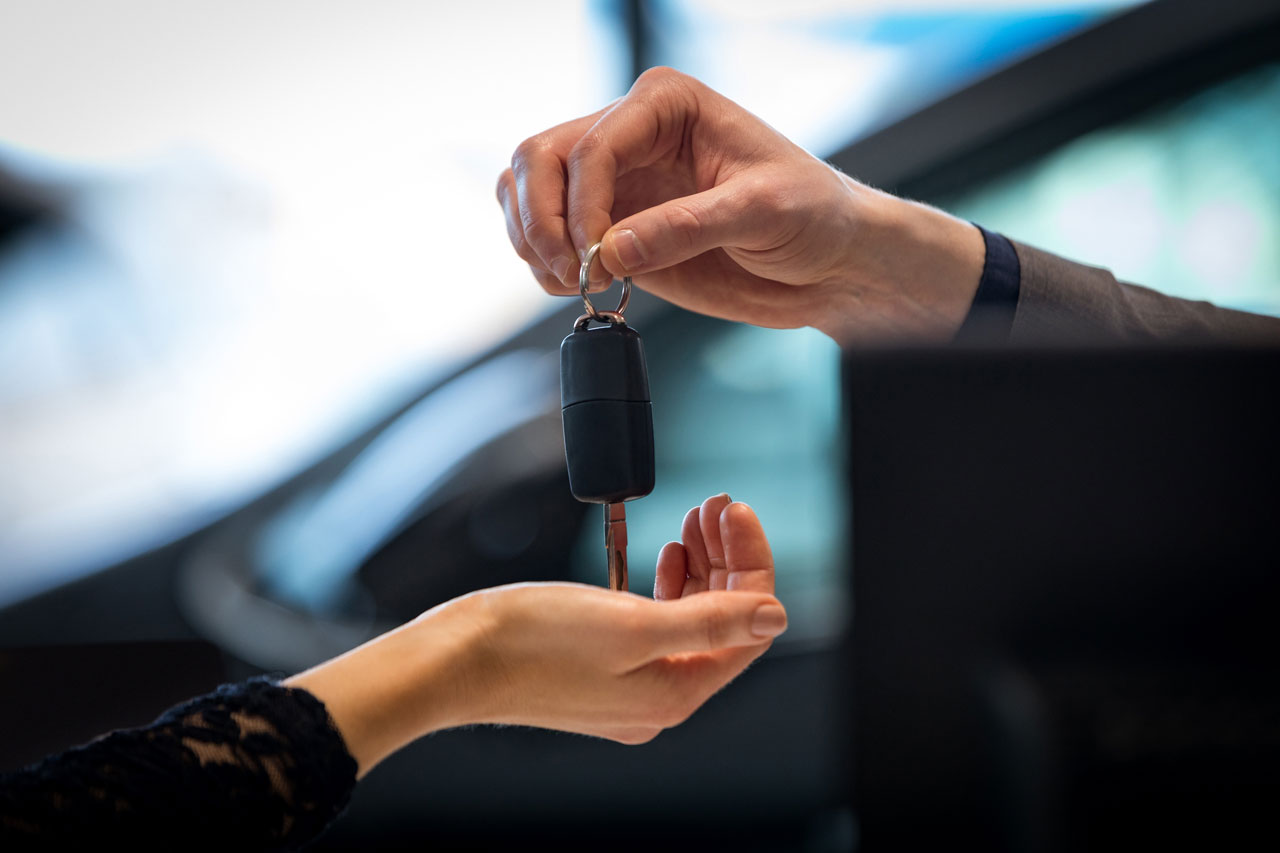 comprar carro com nome sujo - mão entregando chave de carro