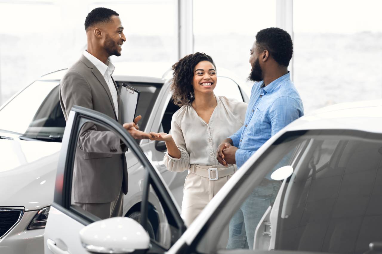 como atrair mais clientes para sua loja - casal comprando veículo ouvindo um vendedor
