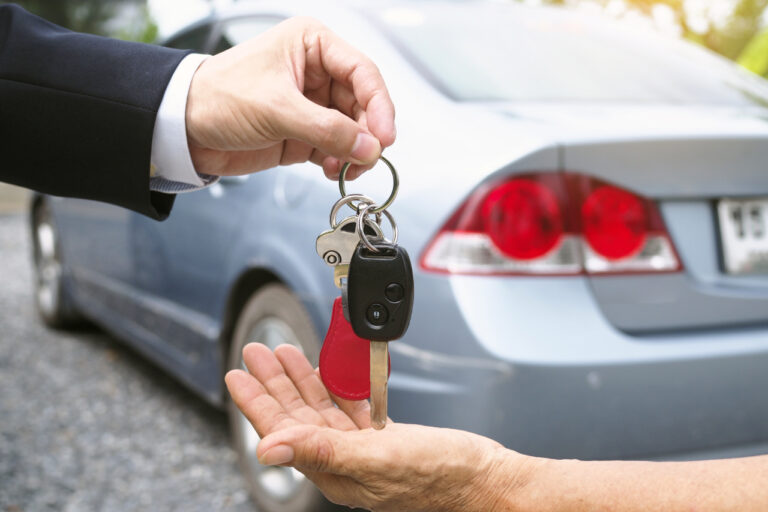 Vender o carro para investir dinheiro - mão entregando chave de carro para outra mão