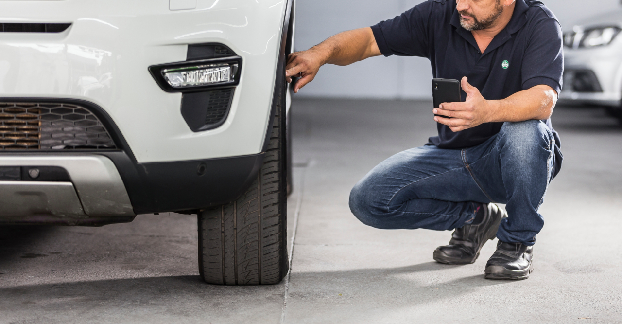Revisão pré-compra na InstaCarro - avaliador conferindo o estado das rodas e pneus do carro
